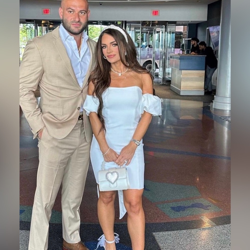 white dress with detachable puff sleeves and a bow in the back